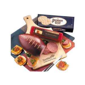 Cutting board with football shaped sausage, cheese, crackers and knife 