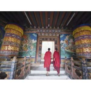  Monks Walking Between Prayer Wheels at Trongsa Dzong 